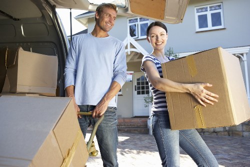 Movers carrying furniture through a Peckham flat with stairs